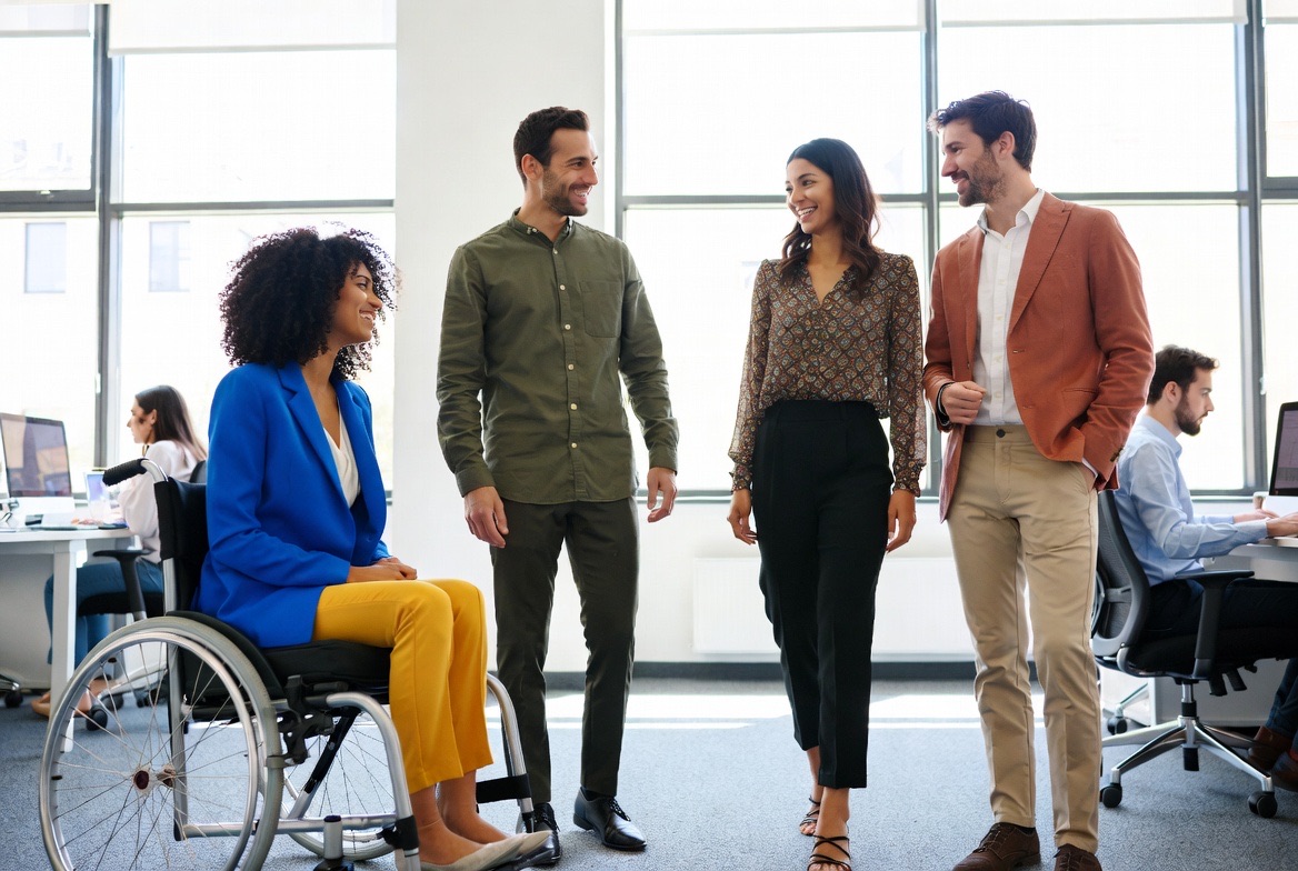 A diverse team walking and talking together in an office corridor